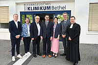 Feierliche Einführung am Evangelischen Klinikum Bethel: Univ.-Prof. Dr. Omid Nikoubashman (Mitte) mit seiner Frau Jenny, wird begrüßt von Pastor Philipp Katzmann, Thorsten Kaatze, Pastor Ulrich Pohl, Petra Krause und Univ.-Prof. Dr. Thomas Vordemvenne (v.r.n.l.).