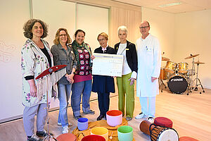 Spendenübergabe für die Musiktherapie: Dietlind Freifrau von Boeselager (3.v.r.) und Eva Thalmann (2.v.r.) übergeben den Spendencheck an die Musiktherapeutinnen Cordula Fach (l.) und Nele Schwier (3.v.l.), die Leitende Psychologin Inga Knipschild und Univ.-Prof. Dr. Eckard Hamelmann. Foto: Manuel Bünemann, Evangelisches Klinikum Bethel