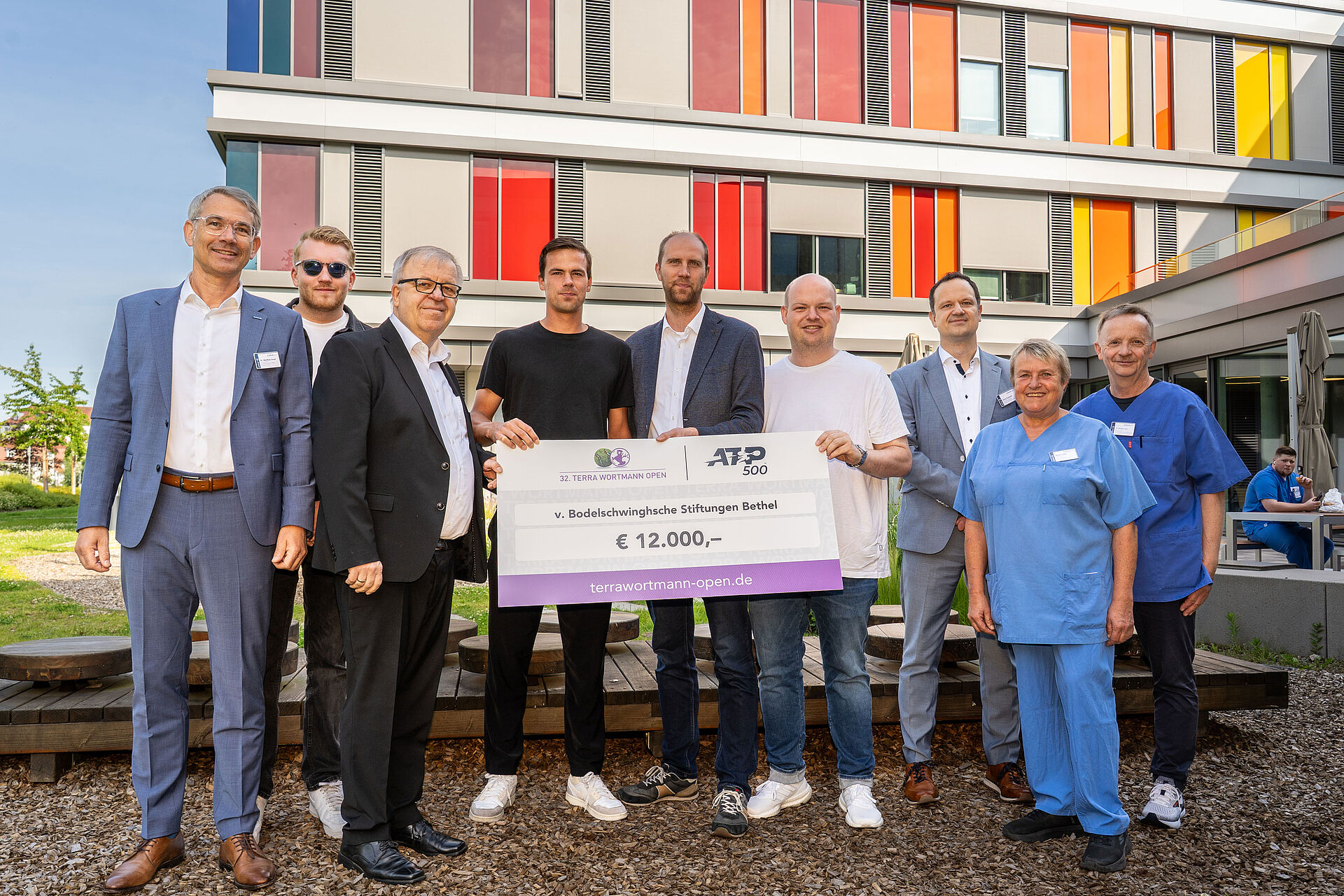 Terra Wortmann Open spenden 12.000 Euro: Tennisprofi Daniel Altmaier besucht das Betheler Kinderzentrum Gruppenfoto mit Spendencheck: Dennis Altmeier (3.v.l.), Christian Anwey (4.v.l.) und Sven Wortmann (5.v.l.) haben einen Spendencheck über 12.000 Euro für das Kinderzentrum Bethel mitgebracht. Dr. Matthias Ernst (l.), Pastor Ulrich Pohl (3.v.l.), Dr. Norbert Jorch (r.), Pflegerische Klinikleitung Birgit Teske (2.v.r.) und Henry Kussauer (3.v.r.) freuen sich, dass die Behandlung von Kindern und Jugendlichen durch die Spende ausgebaut werden kann.