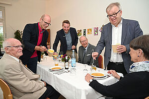 (stehend von links) Ingo Nürnberger, Matthias Rotter und Pastor Ulrich Pohl servieren den Pflegenden Angehörigen (sitzend von links) Alfred Schmalbeck, Dirk Wintzer und Helga Borutta Pastor Pohl das Gala-Diner.