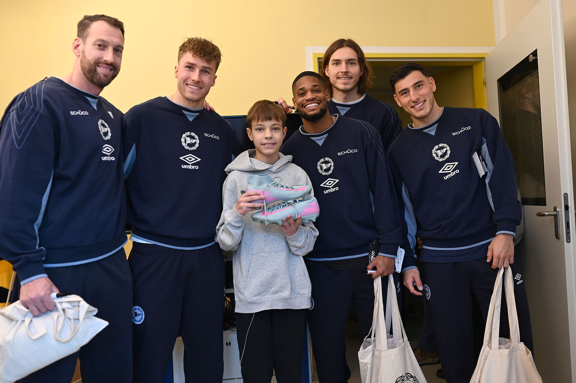 Paul bekommt ein Gruppenfoto mit Mitch Kniat, Joel Grodowski, Isaiah Young, Roberts Uldrikis und Stefano Russo (v.l.n.r.)