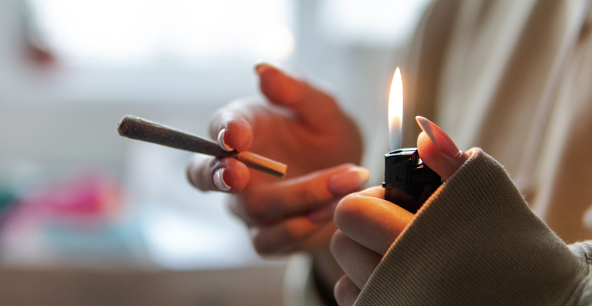 Eine Person zündet sich einen Joint an.