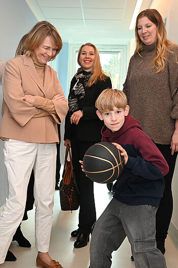 Der neunjährige Niklas zeigt Elke Büdenbender (links), Sylvia Strothotte (Mitte) und seiner Mutter Angela sein liebstes Hobby: Basketball.