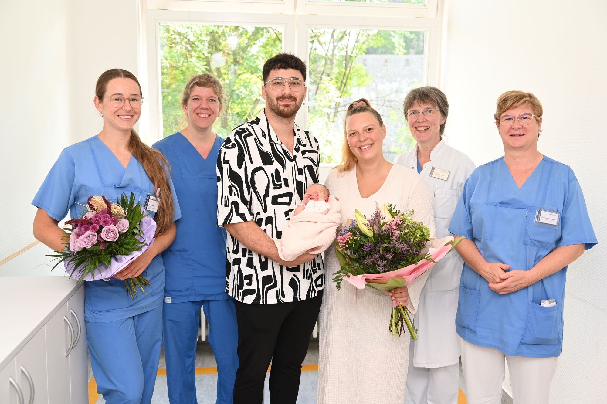 Gruppenbild mit Blumenstrauß: Yael und Daniel Chahrour freuen sich über die Geburt der kleinen Livia. Mit Jana Deppe, Irene Meißner, Dr. Anne Behre-Hille und Gesundheits- und Krankenpflegerin Kerstin Grundmann (v.l.n.r.) kam es zum Austausch von Blumensträußen. Foto: Manuel Bünemann