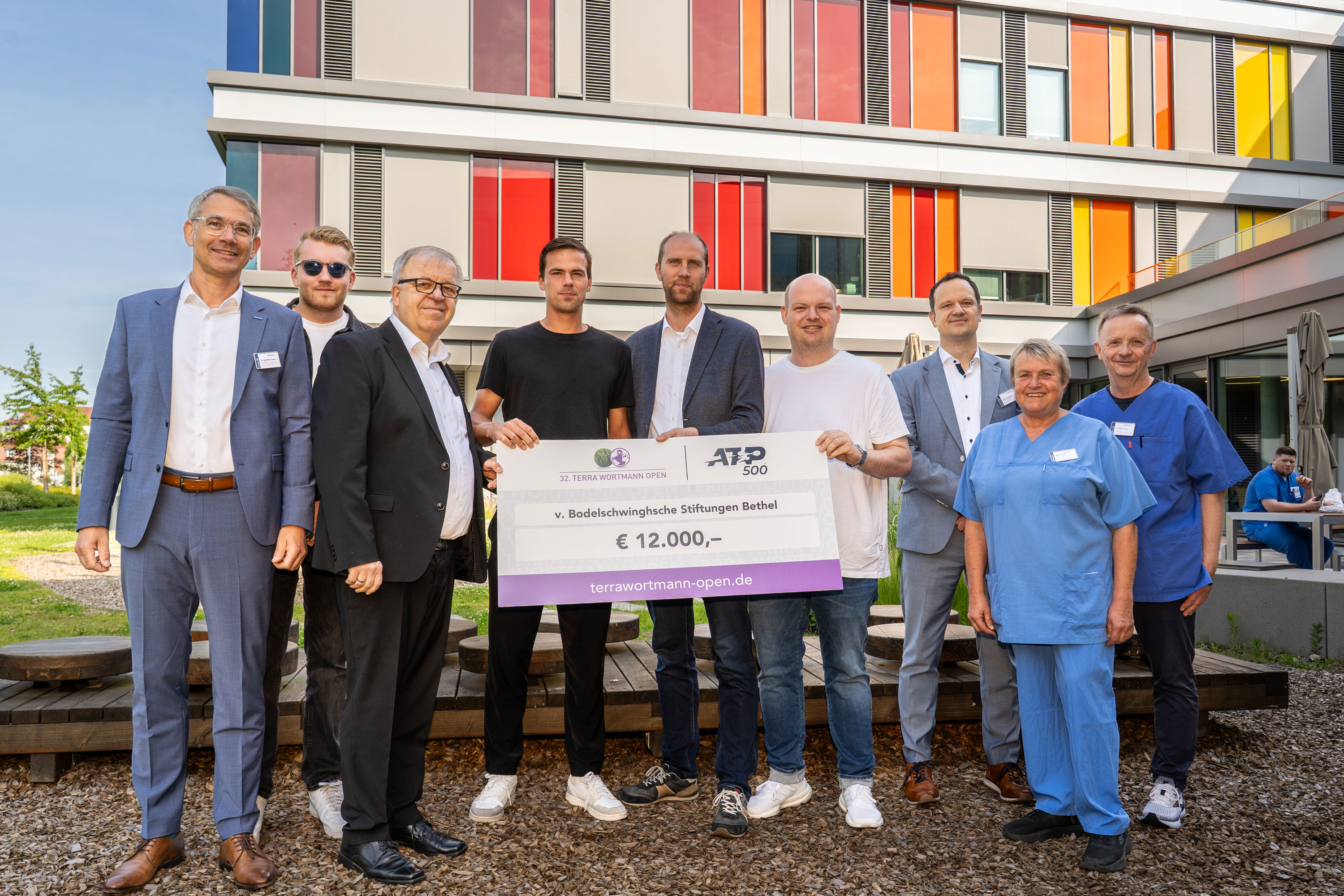 Terra Wortmann Open spenden 12.000 Euro: Tennisprofi Daniel Altmaier besucht das Betheler Kinderzentrum Gruppenfoto mit Spendencheck: Dennis Altmeier (3.v.l.), Christian Anwey (4.v.l.) und Sven Wortmann (5.v.l.) haben einen Spendencheck über 12.000 Euro für das Kinderzentrum Bethel mitgebracht. Dr. Matthias Ernst (l.), Pastor Ulrich Pohl (3.v.l.), Dr. Norbert Jorch (r.), Pflegerische Klinikleitung Birgit Teske (2.v.r.) und Henry Kussauer (3.v.r.) freuen sich, dass die Behandlung von Kindern und Jugendlichen durch die Spende ausgebaut werden kann.