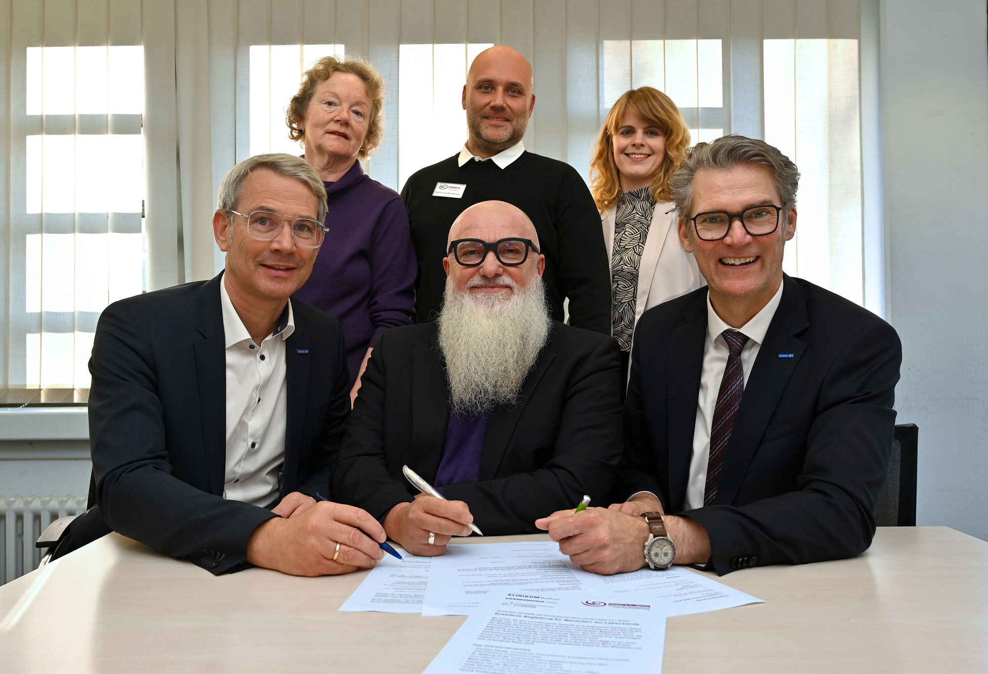 Zusammenarbeit auf einem neuen Level: (vordere Reihe, v. l.) Dr. Matthias Ernst, Vorsitzender Geschäftsführer Krankenhaus Mara, Geschäftsführer EvKB, Mario Höfel, erster Vorsitzender Hospiz e.V., Bethel, Thorsten Kaatze, Vorsitzender Geschäftsführer EvKB und Geschäftsführer Krankenhaus Mara, (hintere Reihe, v. l.) Christine von der Marwitz, Vorstandsmitglied Hospiz e.V., Bethel, Dennis Kuchenbecker, Hospizkoordinator Hospiz e.V., Bethel für EvKB und Mara und Tanja Kirchner, Leitung Klinische Ethik im EvKB und Krankenhaus Mara, freuen sich über die Vertragsunterzeichnung. Foto: Mario Haase