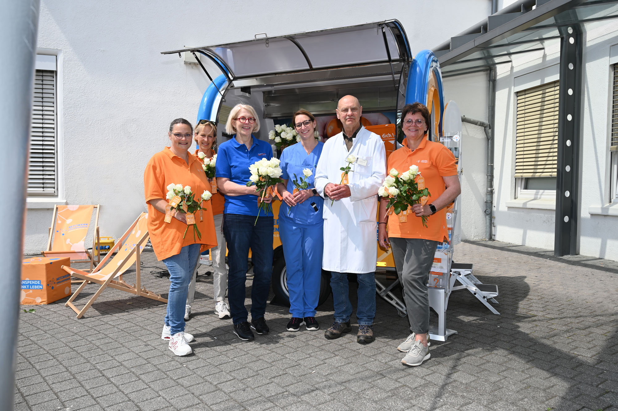 Dank für großes Engagement: Netzwerk Organspende NRW informiert am EvKB Gruppenfoto vor dem Organspendemobil OS-Car: Dank für großes Engagement für die Organspende Dr. Friedhelm Bach und die Pflegerische Transplantationsbeauftragte im EvKB Dorina Zeiger (Mitte) erhalten Besuch von Patinnen des Netzwerks Organspende NRW.