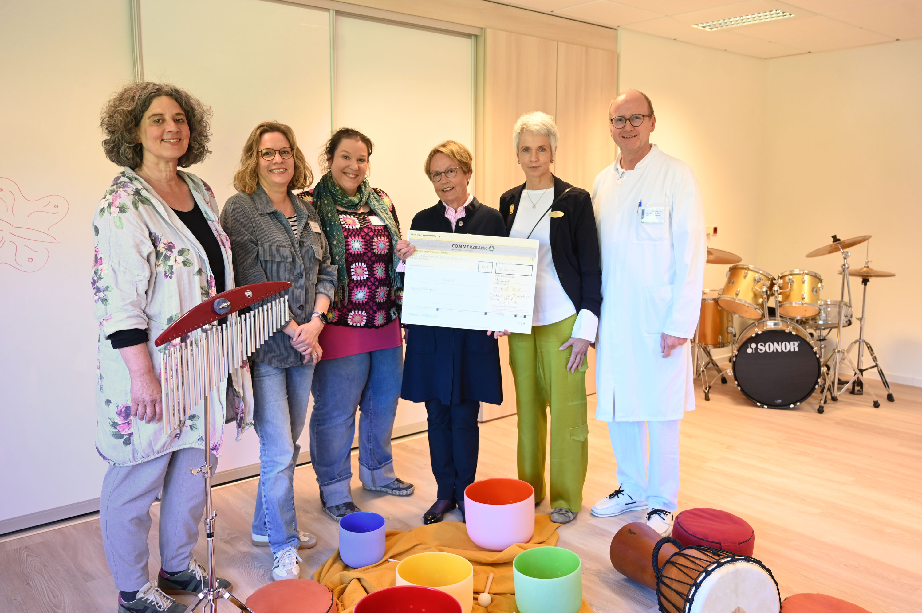 Spendenübergabe für die Musiktherapie: Dietlind Freifrau von Boeselager (3.v.r.) und Eva Thalmann (2.v.r.) übergeben den Spendencheck an die Musiktherapeutinnen Cordula Fach (l.) und Nele Schwier (3.v.l.), die Leitende Psychologin Inga Knipschild und Univ.-Prof. Dr. Eckard Hamelmann. Foto: Manuel Bünemann, Evangelisches Klinikum Bethel