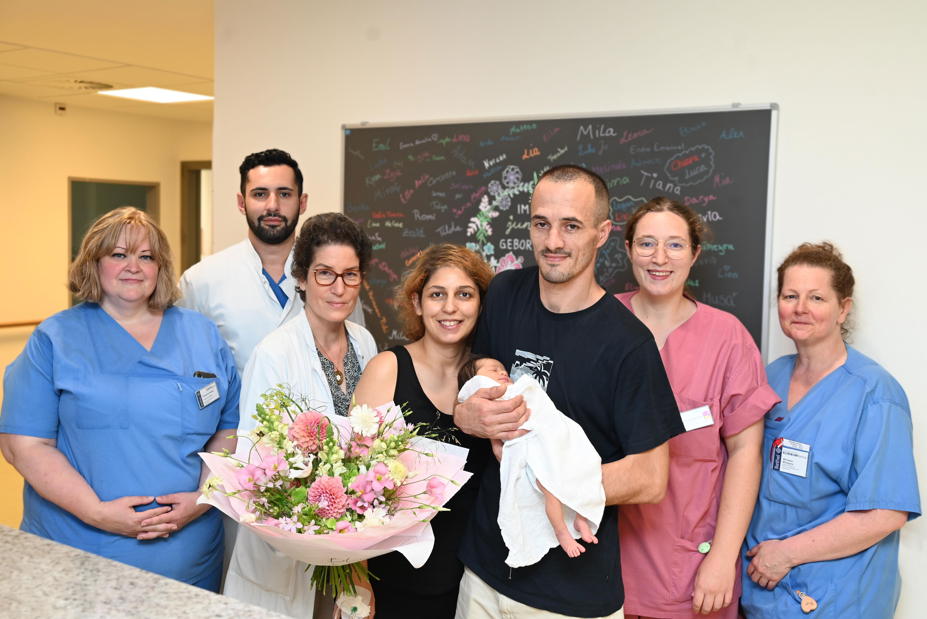 Freude über die neue Erdenbürgerin: Mama Miranda und Papa Perparim mit Tochter Hana erhalten Glückwünsche von der Pflegerischen Klinikleitung Susanne Auster, Oberarzt Dr. Raafat Al Sharba, Chefärztin Prof. Dr. Constanze Banz Jansen, Hebamme Margarita Held und der Leitenden Hebamme Michaela Mülligans (v.l.n.r.) Foto: Manuel Bünemann