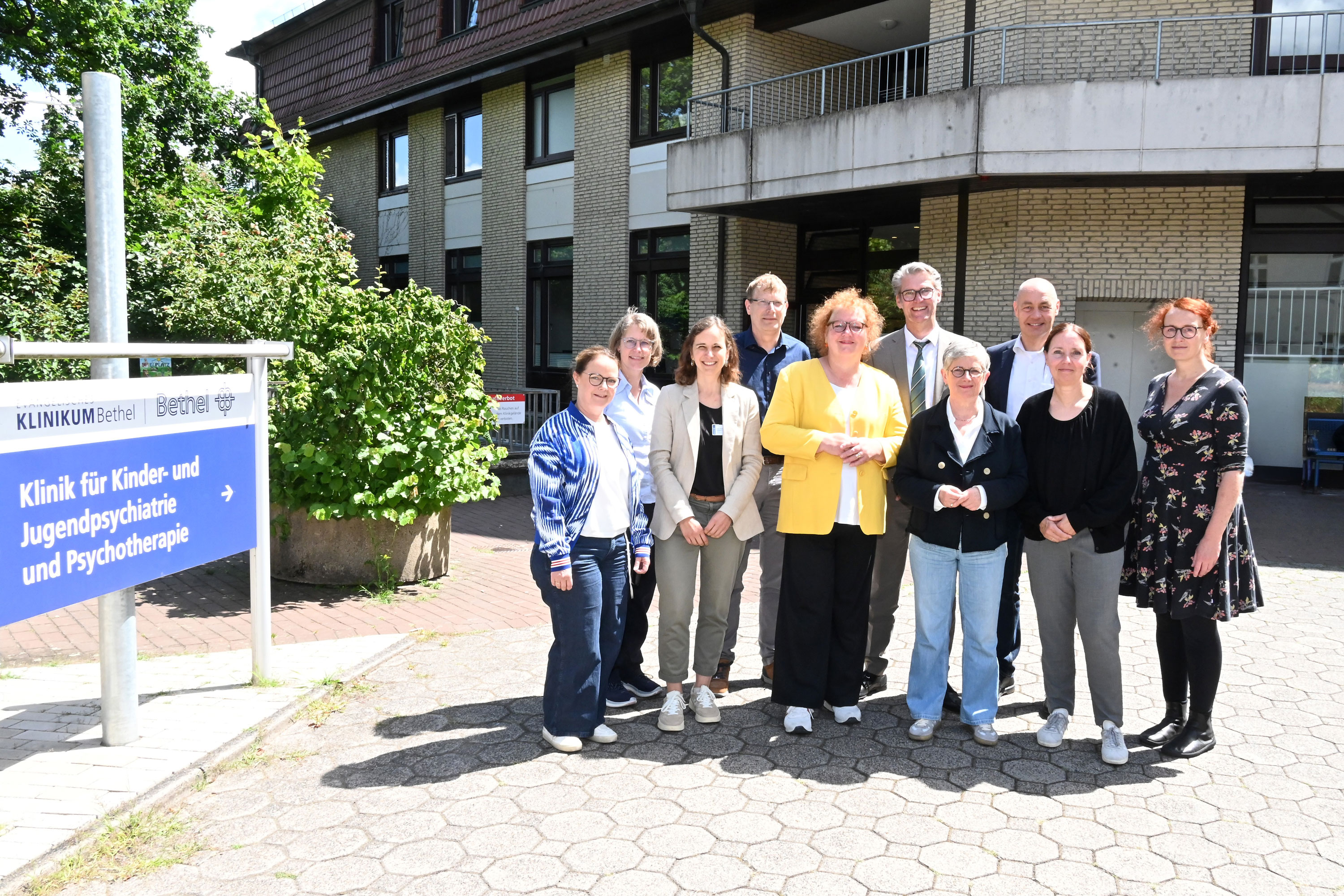 Besuch in Bethel: 1. Reihe: Nicola Steininger | Therapeutische Leitung der Universitätsklinik für Kinder- und Jugendpsychiatrie und Psychotherapie | EvKB, Univ.-Prof. Dr. Stefanie Horndasch | Direktorin der Universitätsklinik für Kinder- und Jugendpsychiatrie und Psychotherapie | EvKB, Christina Osei | MdL und Ratsmitglied Bielefeld | Bündnis 90/Die Grünen, Britta Haßelmann | MdB, Co-Vorsitzende der Bundestagsfraktion | Bündnis 90/Die Grünen, Romy Mamerow | Co-Vorsitzende Ratsfraktion Bielefeld | Bündnis 90/Die Grünen, Kerstin Busch | Bezirksbürgermeisterin Gadderbaum| Bündnis 90/Die Grünen, 2. Reihe: EvKB, Jutta Dörscheln, Pflegerische Leitung der Universitätsklinik für Kinder- und Jugendpsychiatrie und Psychotherapie |EvKB, Joachim Hood | Vorstand Ratsfraktion Bielefeld | Bündnis 90/Die Grünen, Thorsten Kaatze | Vorsitzender Geschäftsführer | EvKB, Pastor Dr. Bartolt Haase | Vorstandsvorsitzender | v. Bodelschwinghsche Stiftungen Bethel. Foto: Manuel Bünemann