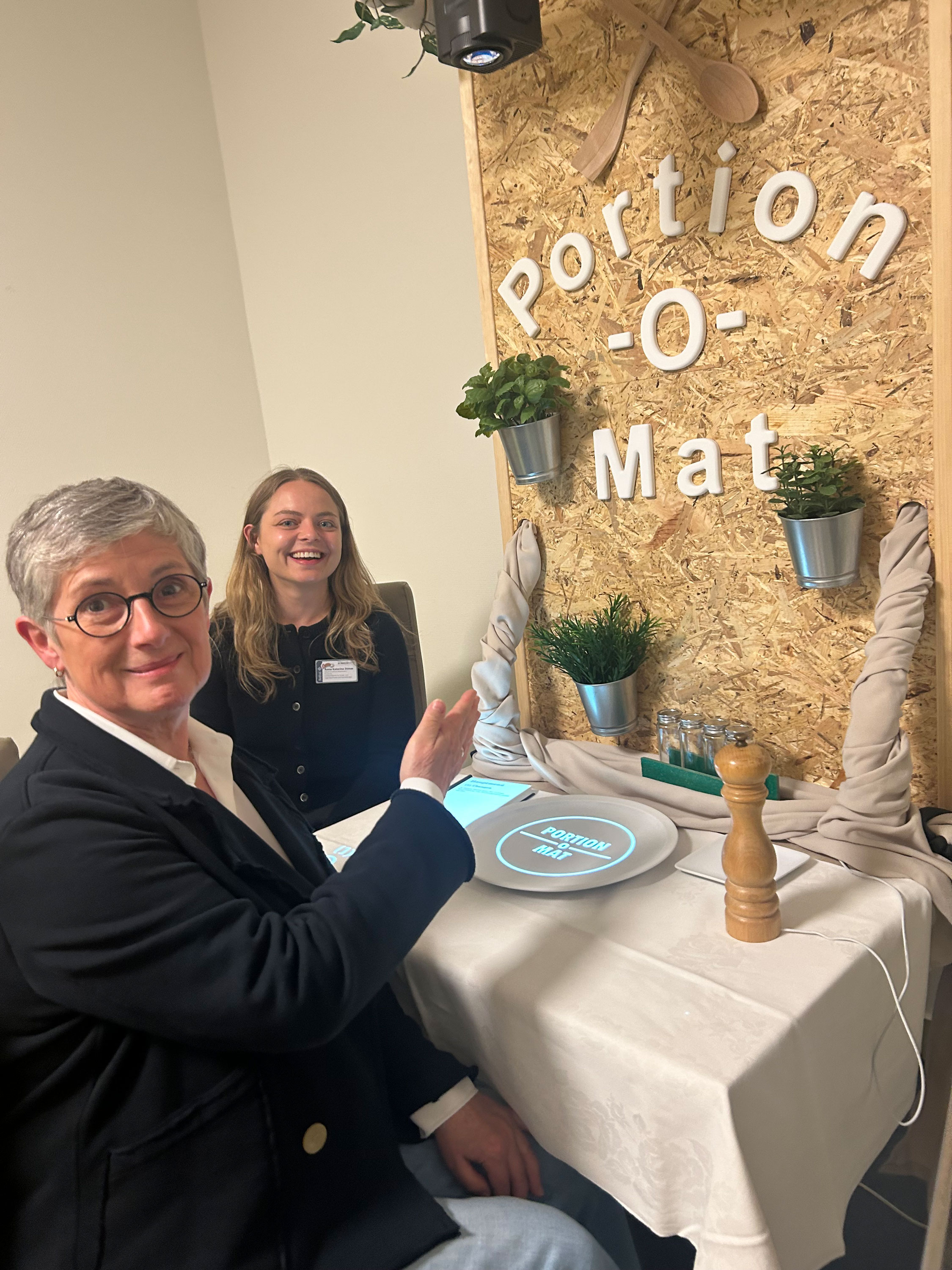 Anna Katharina Dimas (r.) erklärt Britta Haßelmann den neu entwickelten Portion-o-mat, an dem Kinder gesunde Portionsgrößen erlernen können. Foto: Johann Vollmer